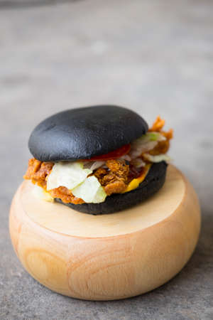 Homemade black burger on a cutting boardの写真素材
