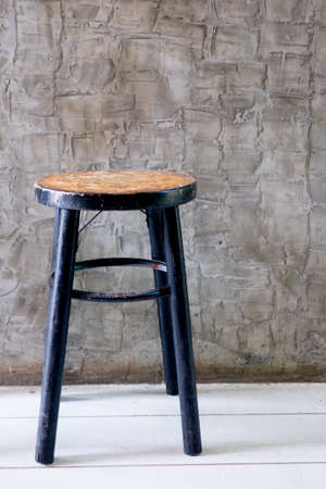 Stool wooden vintage chair withpPolished walls background in loft styleの写真素材