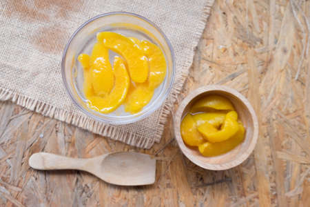 Summer cold drinks: homemade peach soda with sliced peach in wooden bowlの写真素材