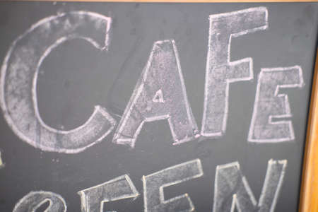 Cafe title written with chalk on blackboard in coffee shopの写真素材