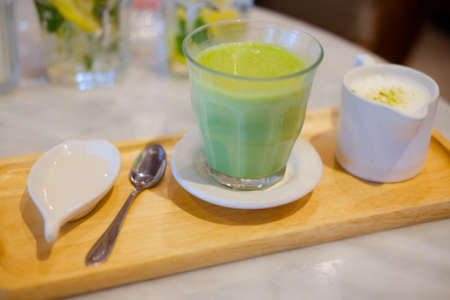 Green tea milk hot cup in coffee shopの写真素材