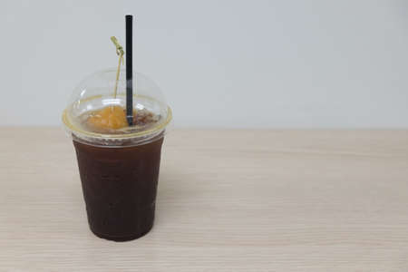 Black coffee with slice peach (Fusion drink) on wood tableの写真素材