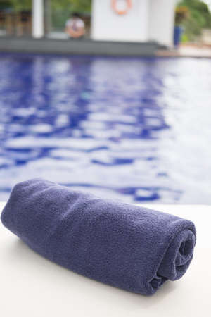 Blue towel roll on sunbeds at swimming poolの写真素材