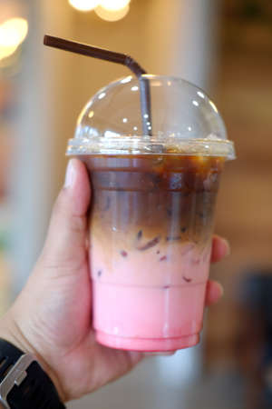 Ice coffee fusion coffee with strawberries syrup in young handの写真素材