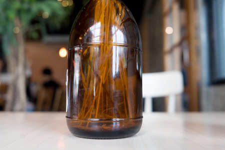 Dry flower in brown glass jar on wood table for decorationの写真素材