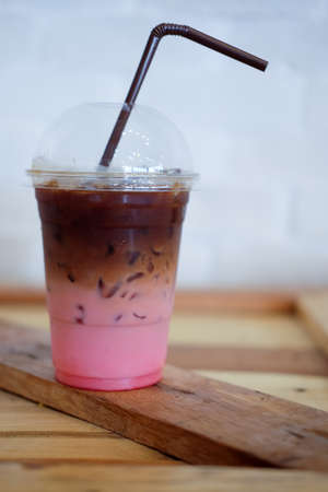Ice coffee fusion coffee with strawberries syrup on wood table in coffee shopの写真素材
