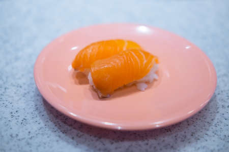 Japanese Sushi - Sake Nigiri Sushi (Salmon Sushi) on pink dishの写真素材