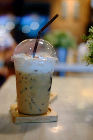 Cold coffee drink with ice on wood tableの写真素材