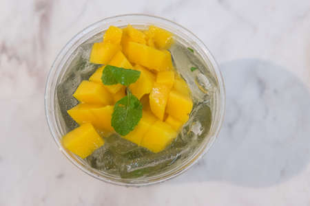 Mango ice tea with slice mango and mint in a glassの写真素材