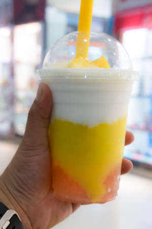 Yogurt pudding with slice of mango in takeaway cupの写真素材