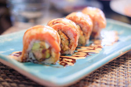 Salmon sushi rolls in a beautiful blue plateの写真素材