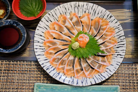 Thin slices of salmon in a Japanese sushi barの写真素材