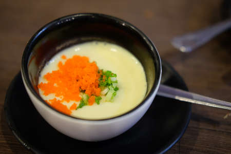 Delicious steamed egg topping with shrimp eggs in black plateの写真素材