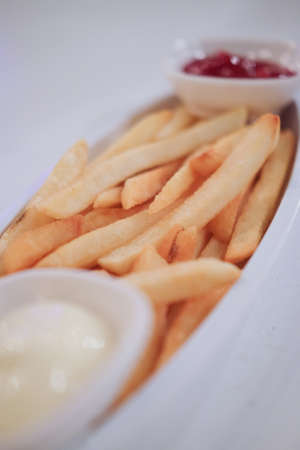 French fries serve with ketchup and sour cream on tableの写真素材