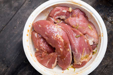 Raw pork slice meat in big bowl ready for cookの写真素材