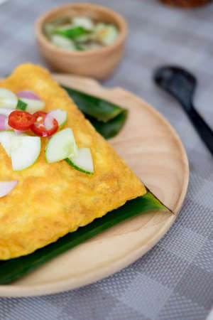 Pastry stuffed crispy egg crepe on wood dishの写真素材