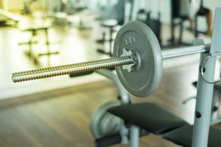 The bar with dumbbells in focus. Barbell ready for workout.