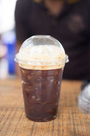 Iced Americano black coffee on a wooden table