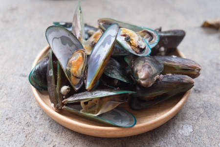 Close up of appetizing fresh steamed mussels on wooden dishの写真素材