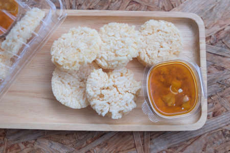 Crispy rice crust pile with sweet pork sauce on wooden trayの写真素材