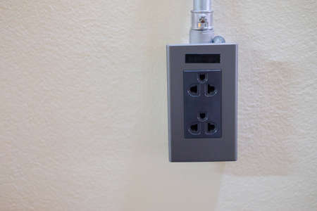 Electrical outlet plug in a cement wallの写真素材