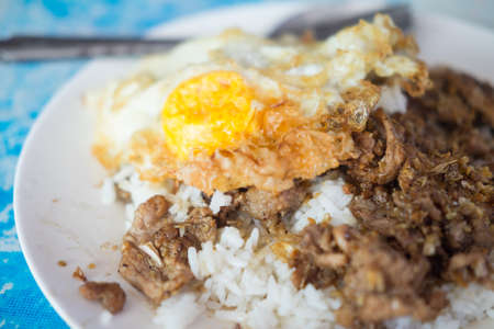 Fried pork with garlic, pepper and fried egg on rice. Easy Thai foodの写真素材