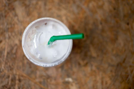 Close up of iced coffee with green straw, top viewの写真素材