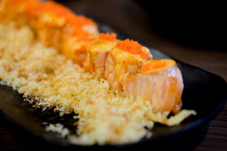Close-up of salmon rolls on black dishの写真素材