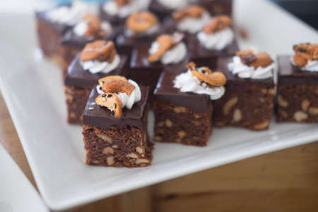 Dark chocolate brownies topping with cashew nut and cream (selective focus)の写真素材