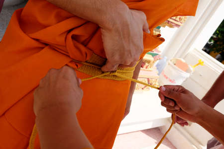 Close-up shot of monk dressing from master to new monk.の写真素材