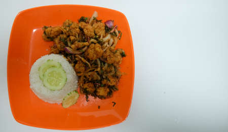 Thai cuisine spicy crispy pork served with rice in orange dish, top viewの写真素材