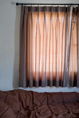 Closeup with brown color curtain in brown bed in bedroomの写真素材