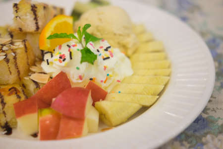 Ice cream with apple orange and banana dessert in cafeの写真素材