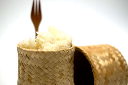 Closeup sticky rice in bamboo container on whiteの写真素材
