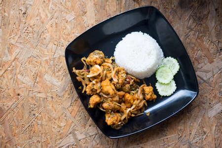 Spicy salad fried chicken with cooking rice on wood backgroundの写真素材