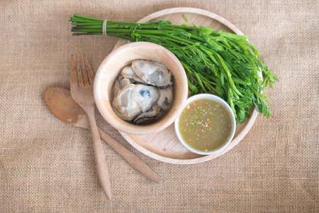 Fresh oysters in Thai style with chili paste seafood sauce and deep fried red onionの写真素材