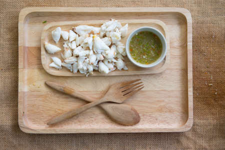 Crab meat cooked served with seafood sauce on wood tray, top viewの写真素材