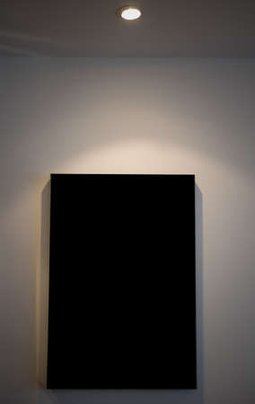 Empty picture frame in a room against a white wallの写真素材