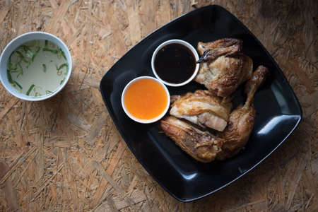 Grilled chicken with spicy sauce on black dish, Thai Style foodの写真素材