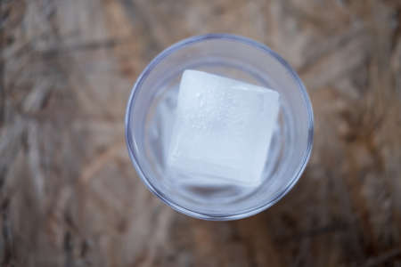Ice cubes in a glass on wooden background. refreshment conceptの写真素材