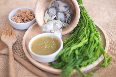 Fresh oysters with fried red onion and seafood chili sauce. Thai cuisine style.の写真素材