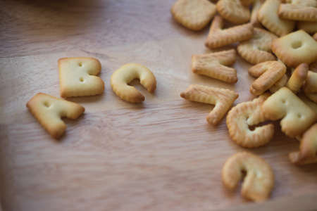 Alphabet cracker word ABC in wooden dish backgroundの写真素材
