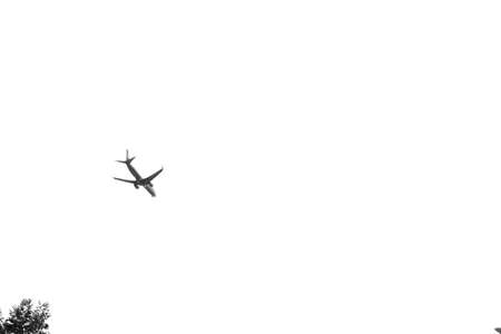 Photo of flying airplane in white sky