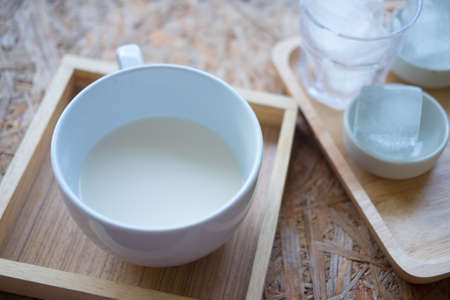 A white cup with fresh milk served on wood boxの写真素材