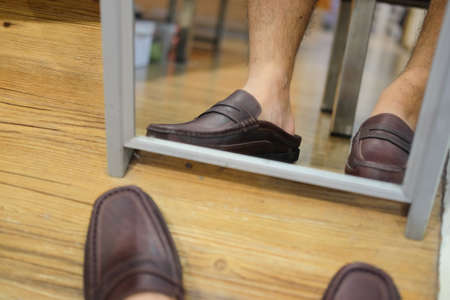 Man wears a classic leather shoe in shoe store