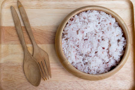 Bowl with brown rice on wood tray, top viewの写真素材