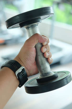 Young man keeping iron dumbbellsの写真素材