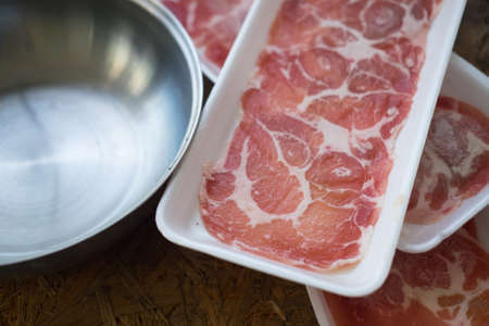 Raw kurobuta pork slices on plates for sukoyaki and yakiniku hot pot shabu japanese foodの写真素材