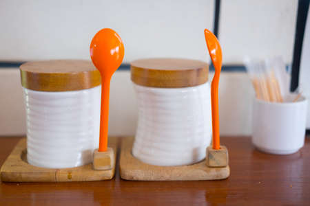 Sugar ceramic jar with orange spoon decorative on table in resturant.