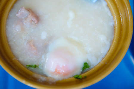 rice porridge with pork topping egg yolk in bowlの写真素材
